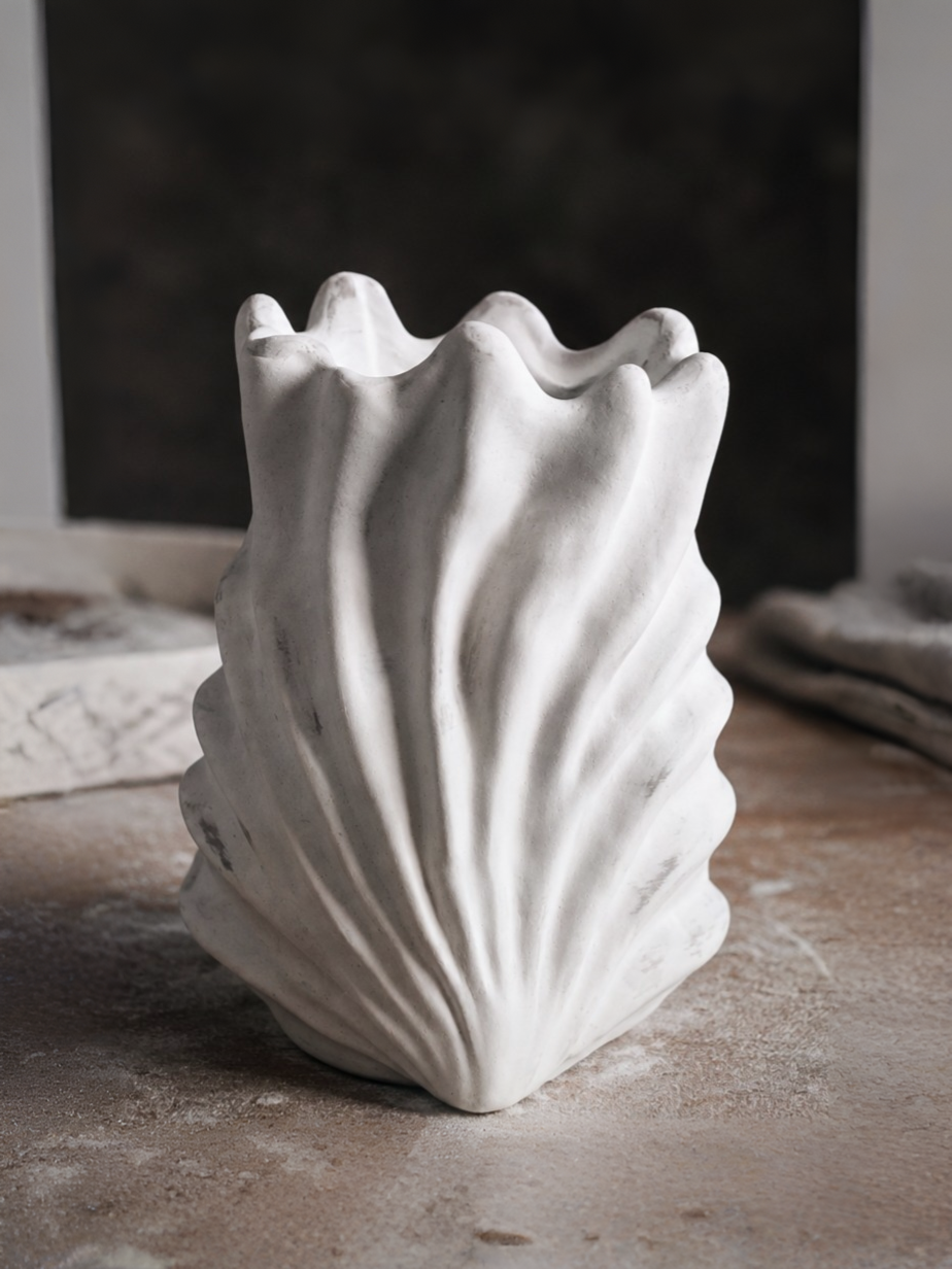 Refined hand-sculpted master model of a fluted shell vase in the workshop